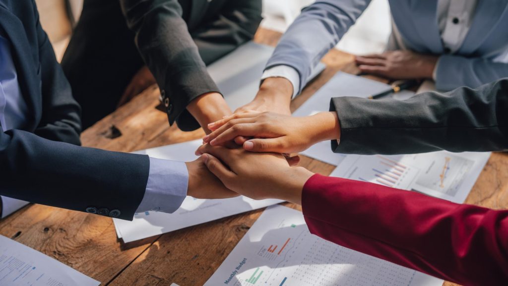 Ejecutivos juntando las manos sobre una mesa